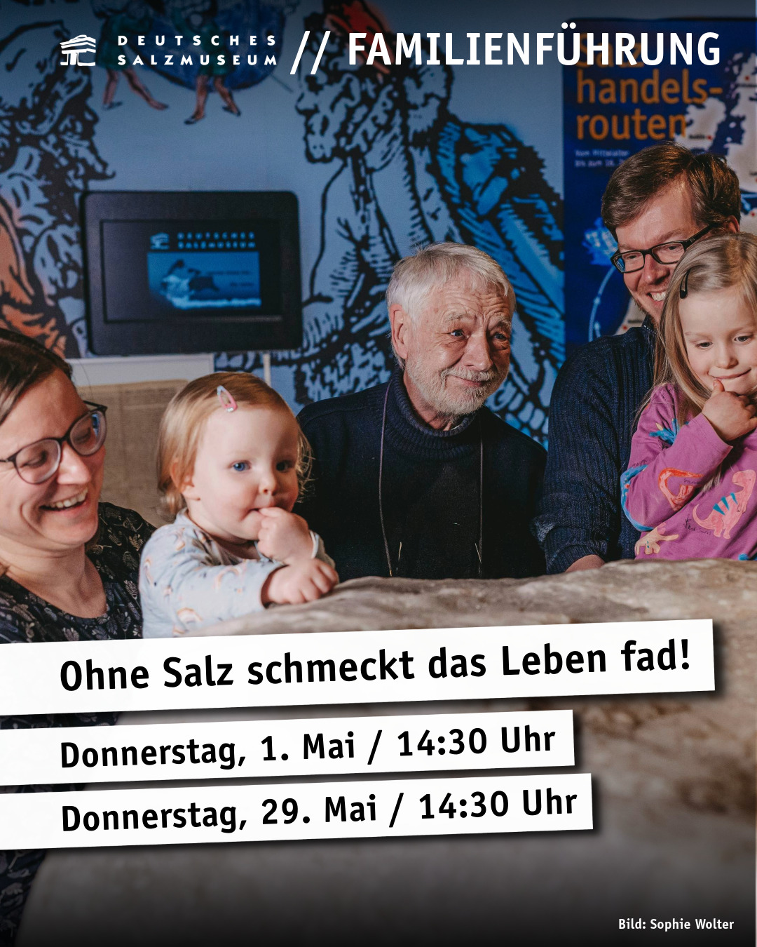 Eine Familie steht im Salzmuseum Lüneburg an einem großen Salzblock.